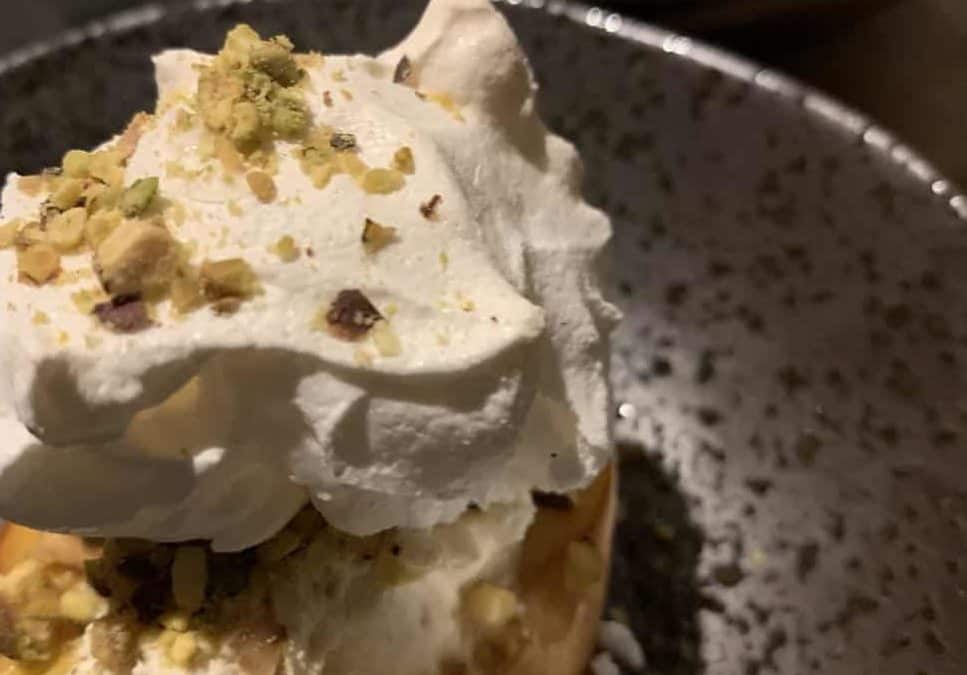 Poached nectarine with meringue and pistachio